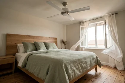Ventilateur de plafond ultra silencieux installé dans une chambre parentale moderne avec literie en lin vert sauge et parquet chêne